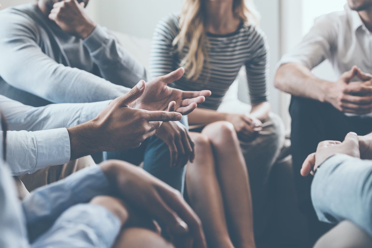 A group of people sitting around each other.