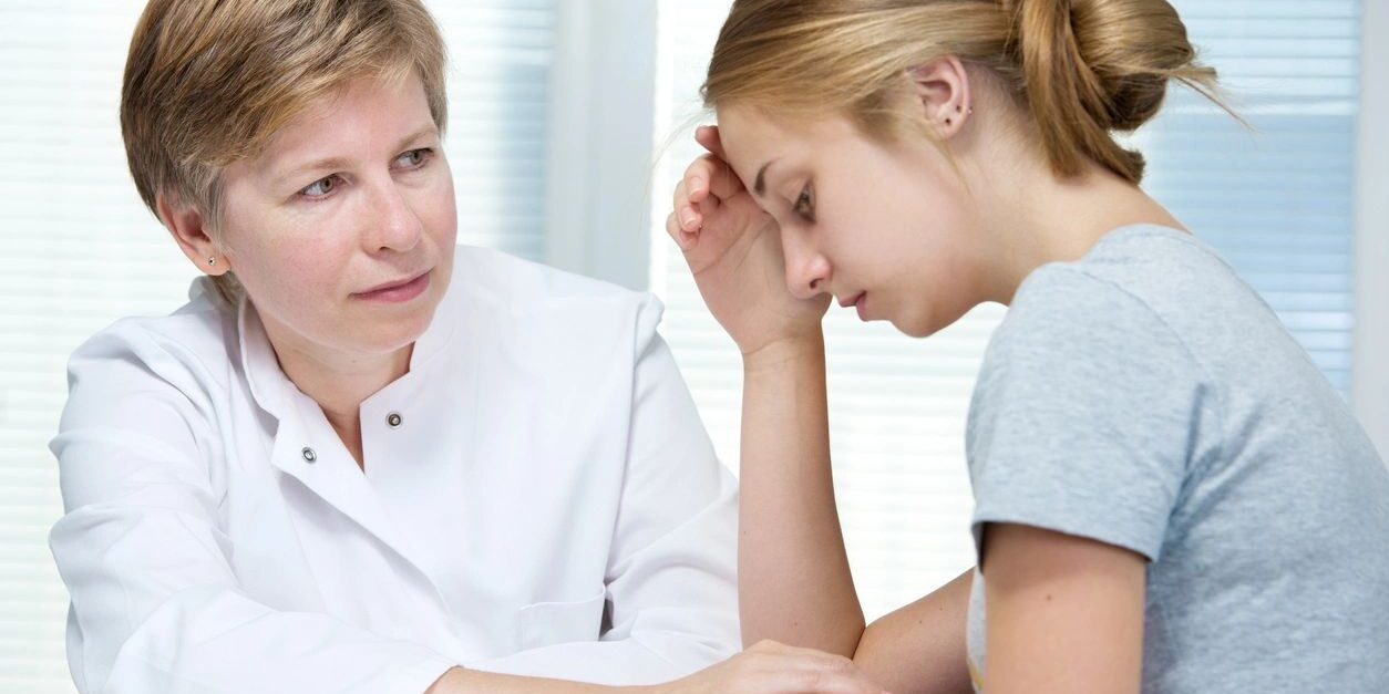 A woman sitting next to a doctor in front of a table.